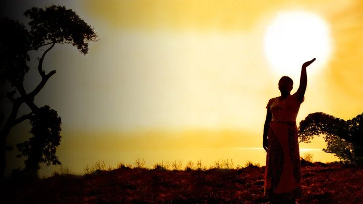A woman holding coffee cherries in the sunlight